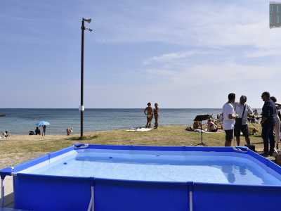 Domenica circa duecento evangelici si sono riuniti a Pane e Pomodoro, dove avrebbero dovuto ribattezzarsi in mare. Ma il divieto di balneazione deciso dopo le piogge della sera prima ha costretto a un cambio di programma: cos� i fedeli si sono attrezzati con una piscina portatile